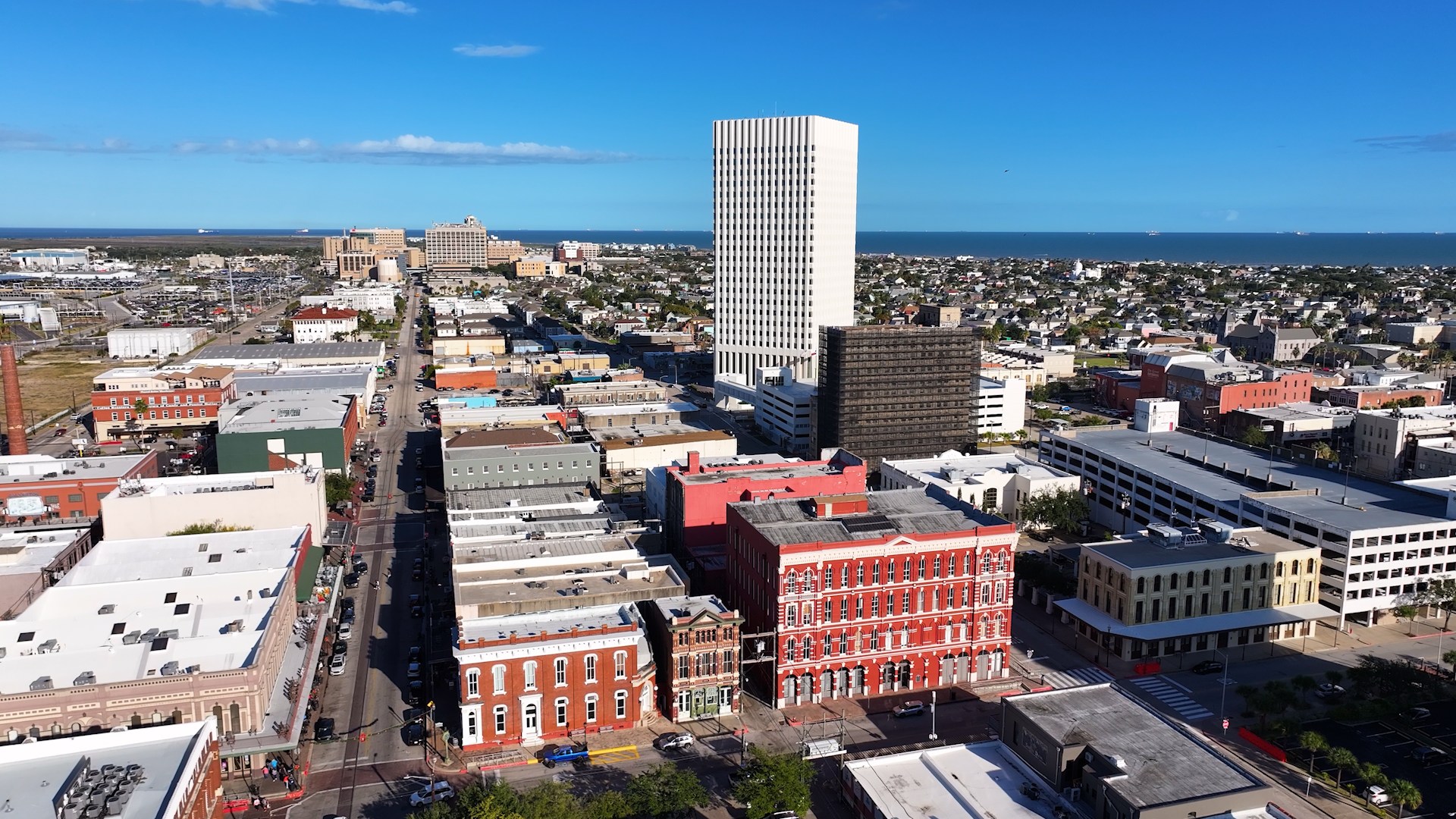 Aerial view of downtown Galveston showing historic blocks, civic buildings, the working waterfront, nearby neighborhoods and the Gulf