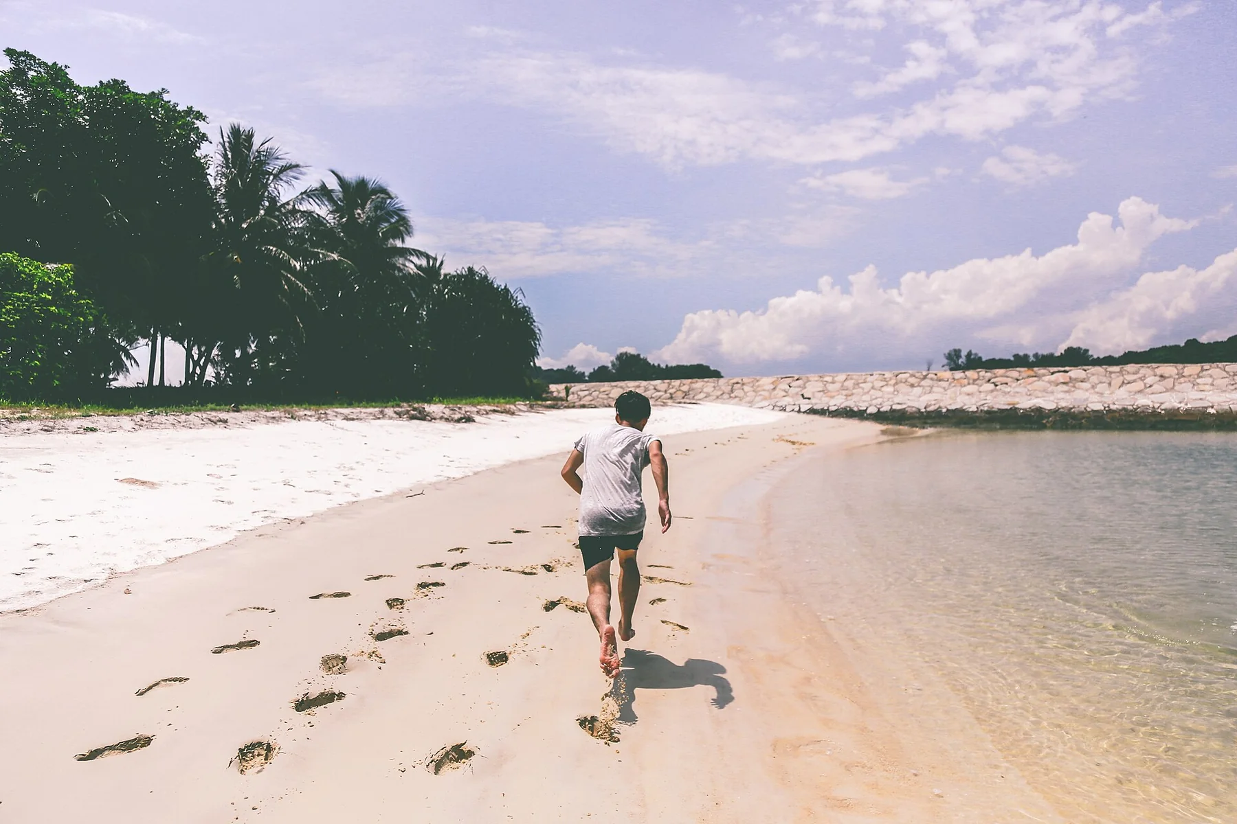 A runner leaving footprints on a beach at low tide