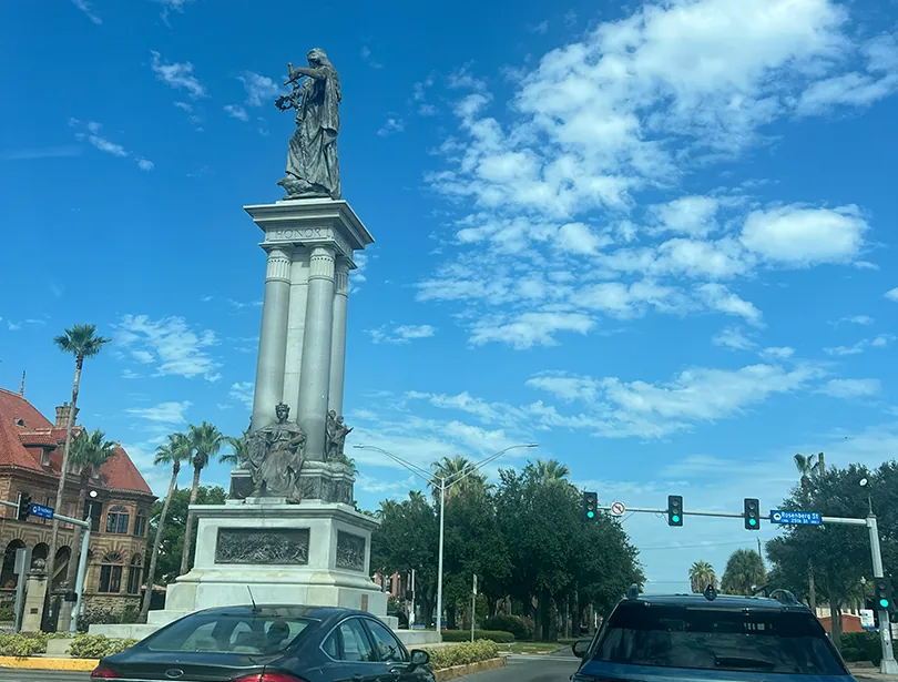 Traffic lights and the Texas Heroes Monument along Broadway in Galveston.