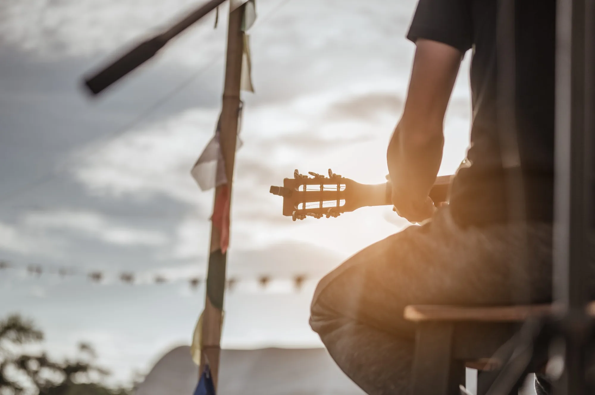 A guitarist silhouetted against a bright sunset.