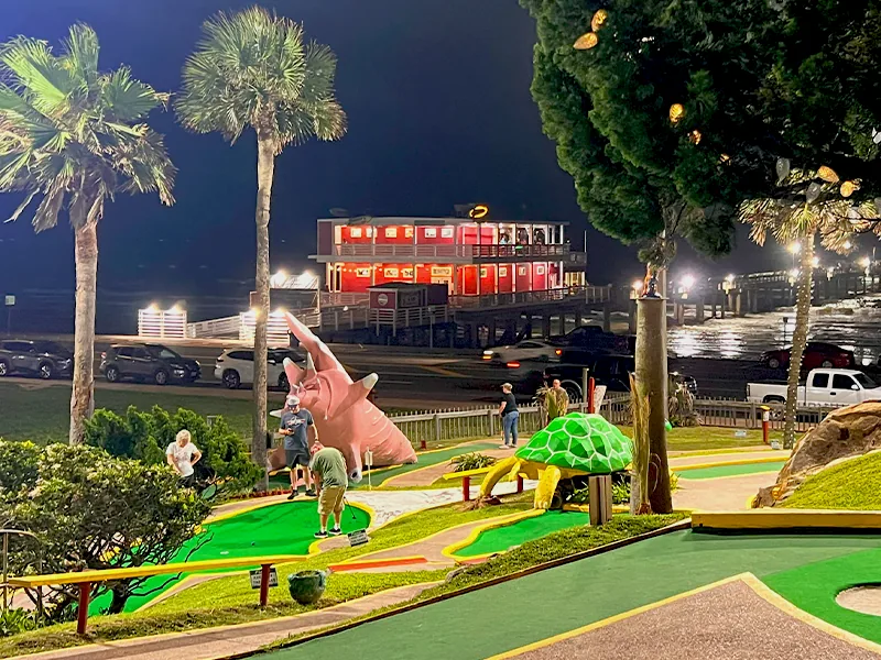 An illuminated miniature-golf course near Galveston's Seawall at night.